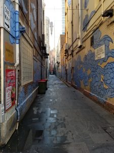 Picture of the Between Two Worlds art installation in Sydney. Blue painted "auspicious clouds" stretch down an alley.